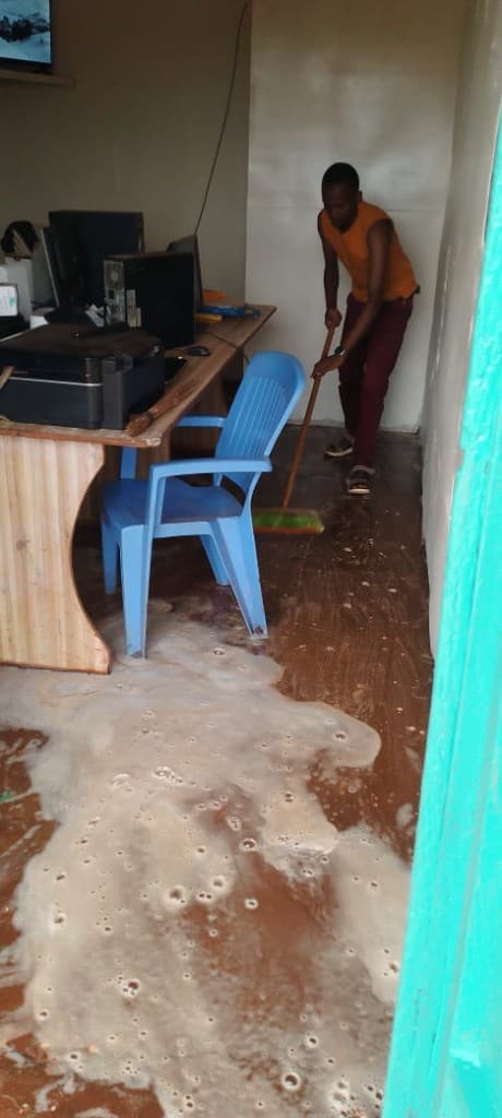 A PKN team member sweeping out floodwater to reopen the lab.