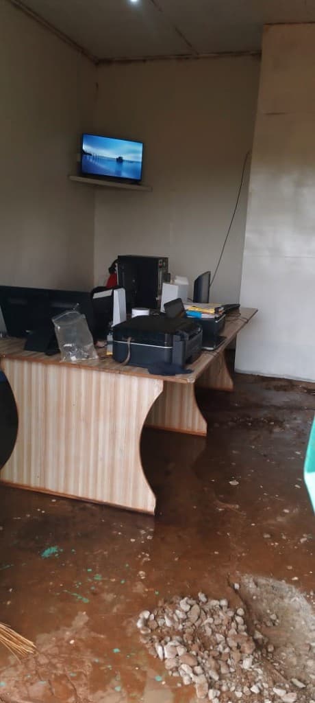 Storm flooding leaves mud across the lab floor, with equipment kept safe on raised desks.