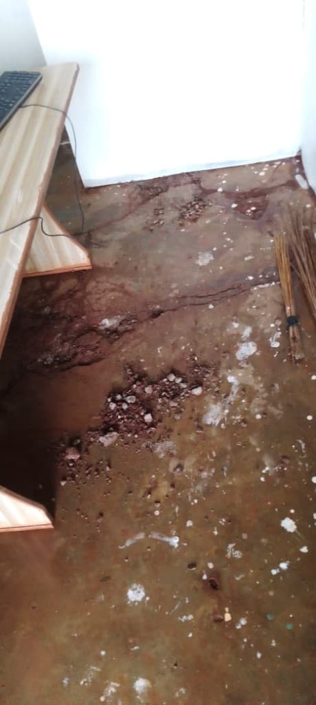 Floodwater and silt cover the lab floor after heavy rains.